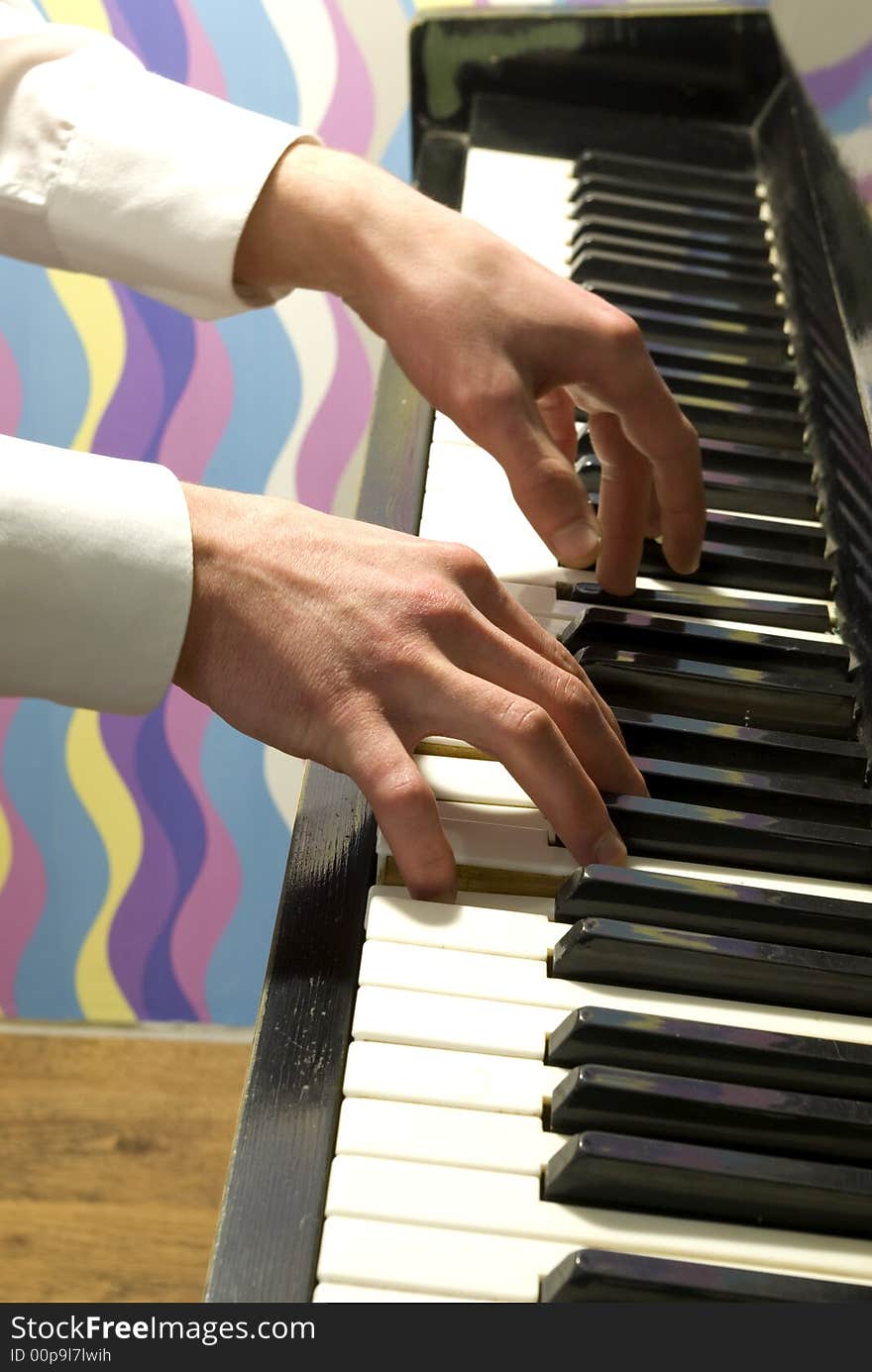 A closeup of a pair of hands playing a piano.