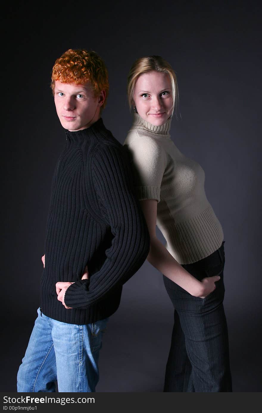 Blond girl and redhead boy on black background. Blond girl and redhead boy on black background