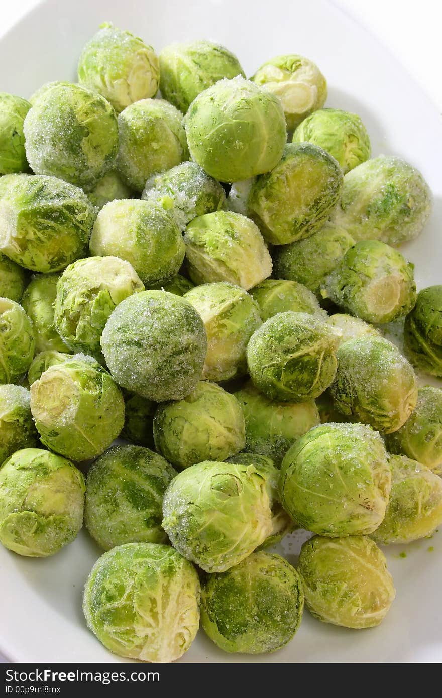 Frozen Brussel Sprouts in a bowl on bright background