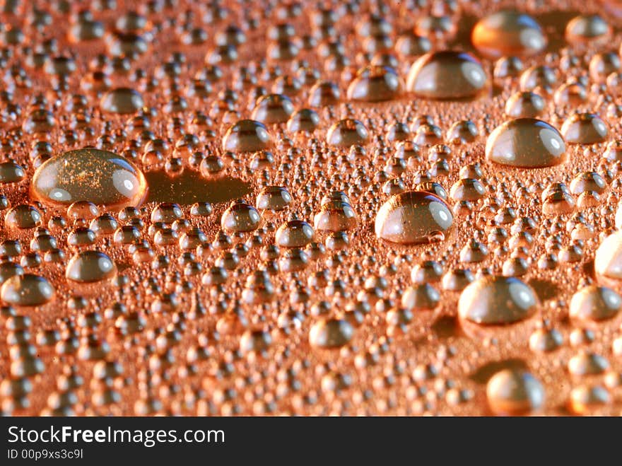 Copper colored water drops close up. Copper colored water drops close up