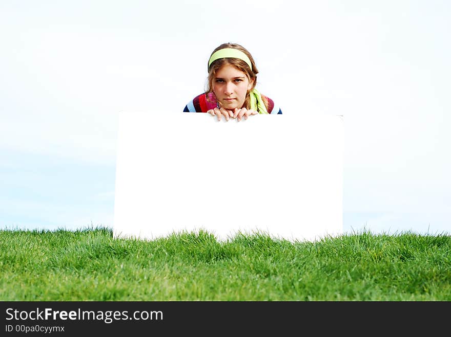 Young girl is holding a blank board at outdoor location. Young girl is holding a blank board at outdoor location