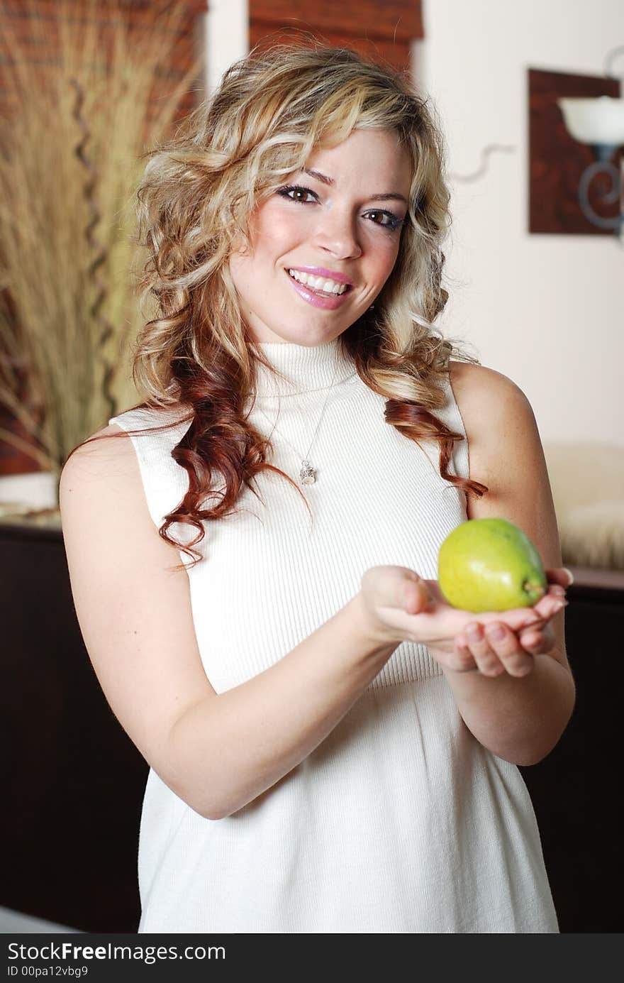 Beautiful woman is holding a fruit in her hands. Beautiful woman is holding a fruit in her hands