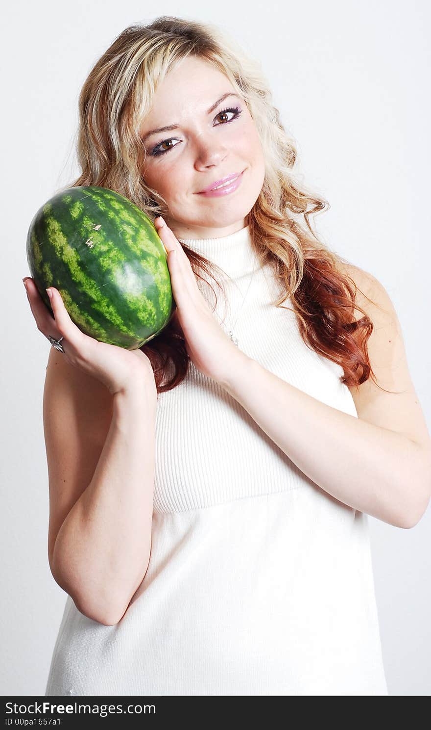 Beautiful woman is holding a fruit in her hands. Beautiful woman is holding a fruit in her hands