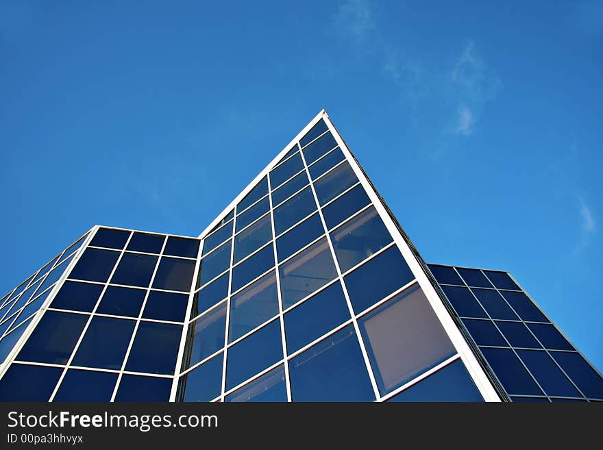 Modern new office building against a bright blue sky. Modern new office building against a bright blue sky.