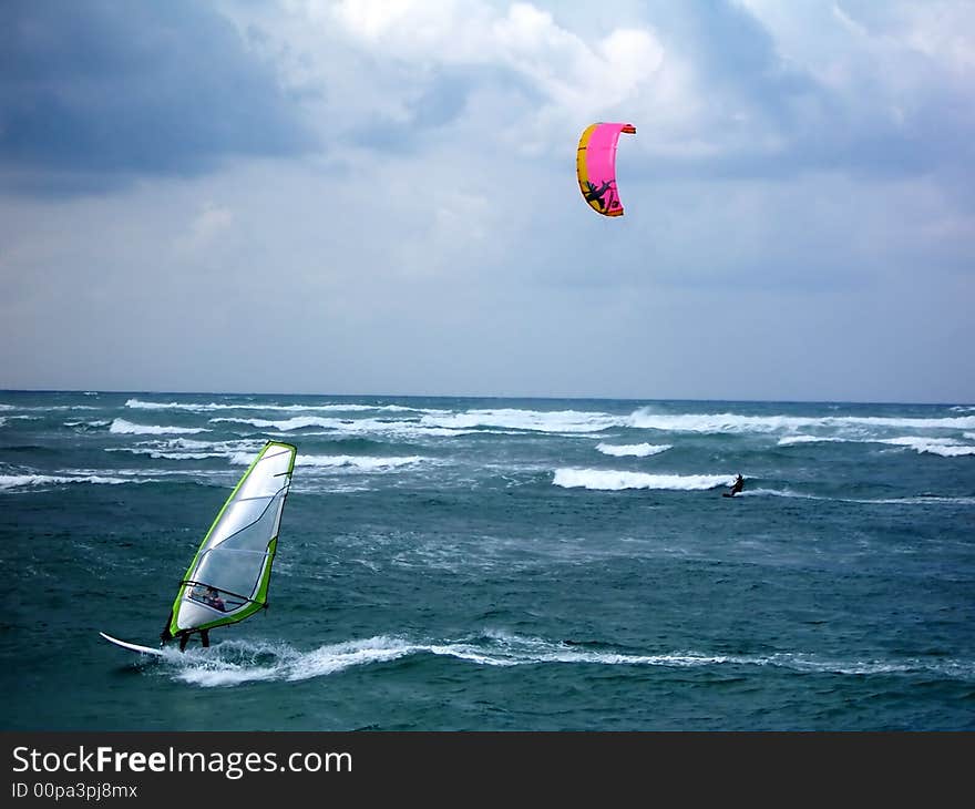 Windsuгfing on the waves of sea on the sky's background