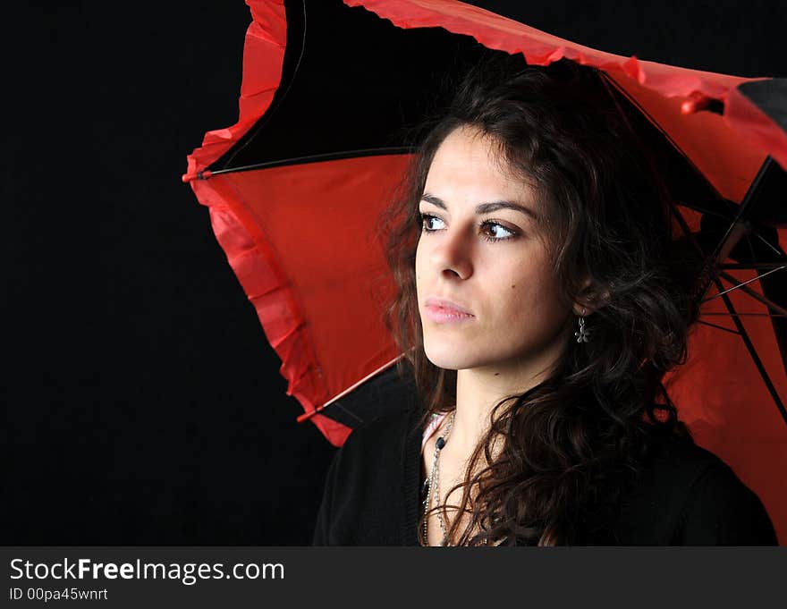 Beautiful brunette with umbrella on black background