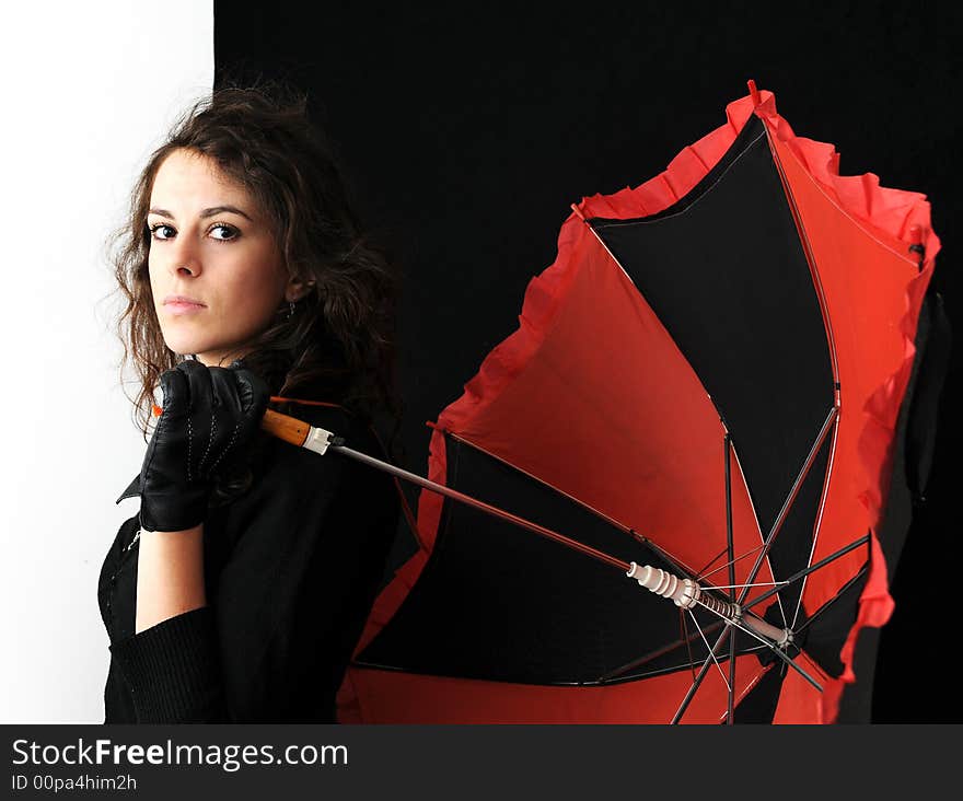 Beautiful brunette with umbrella on black background