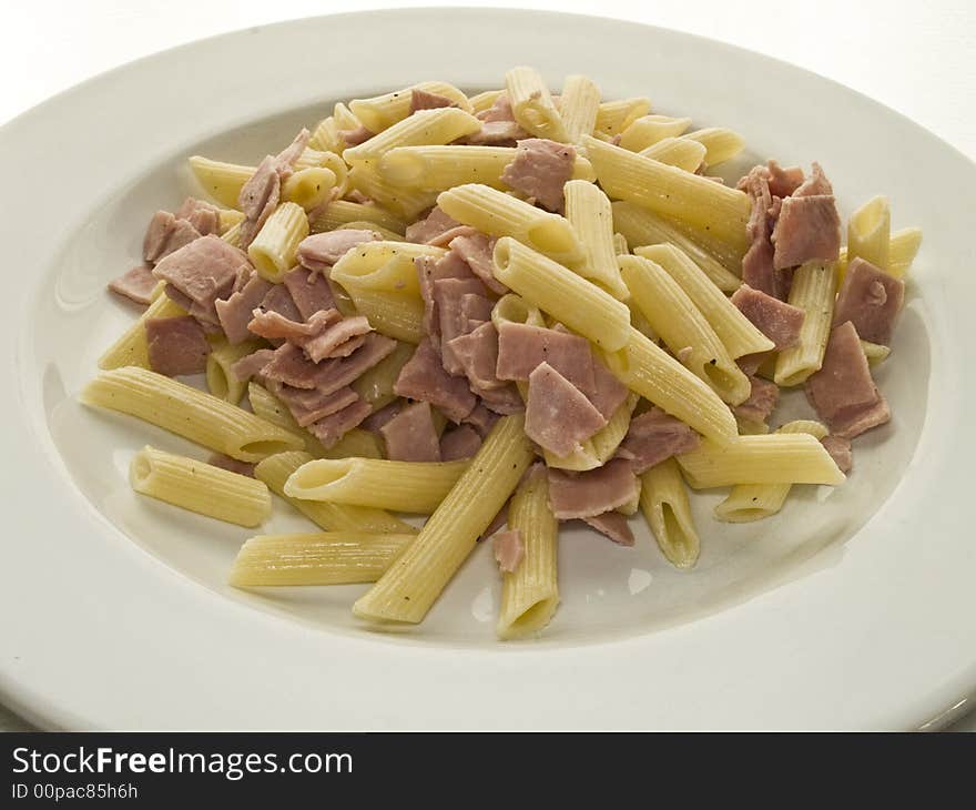 Dish of noodles and ham with sauce on a white plate. Dish of noodles and ham with sauce on a white plate