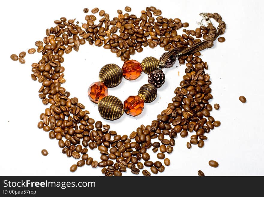 Grains of coffee in the form of heart and a beads. Grains of coffee in the form of heart and a beads