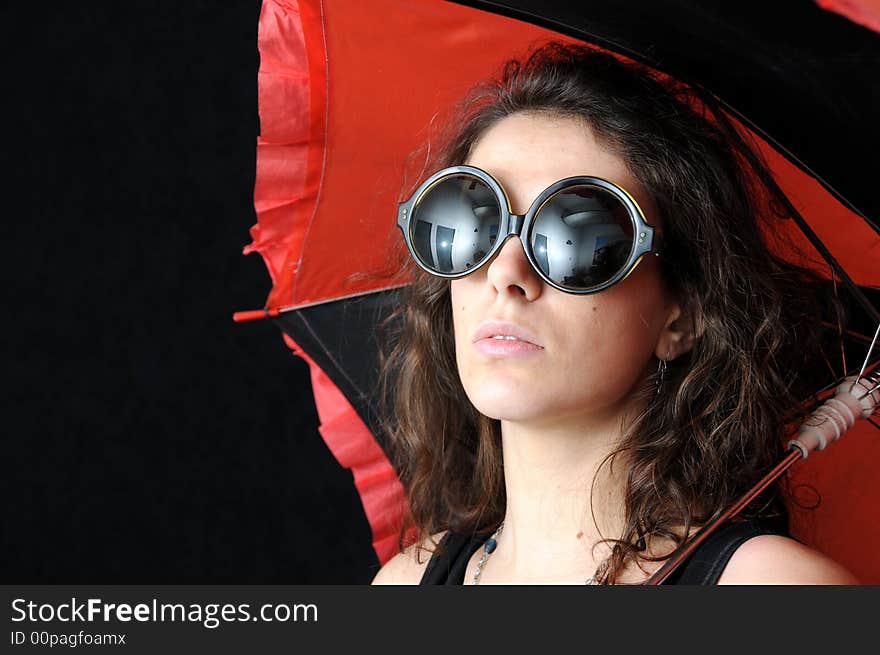 Beautiful brunette with umbrella on black background