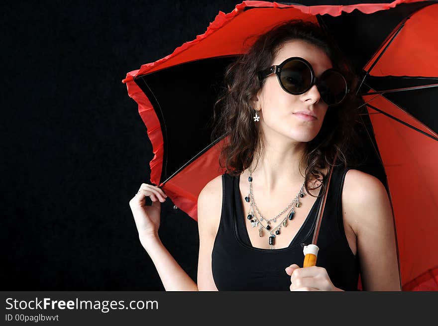 Beautiful brunette with umbrella on black background