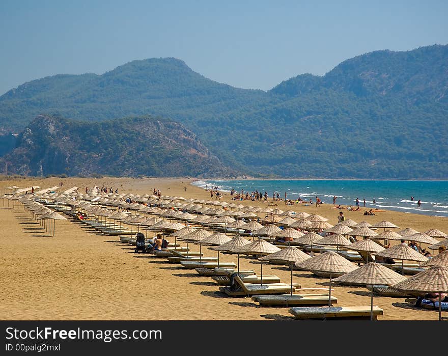 Line of sunshades on the beach sand at the endge of Mediterranian and Aegean Seas. Line of sunshades on the beach sand at the endge of Mediterranian and Aegean Seas