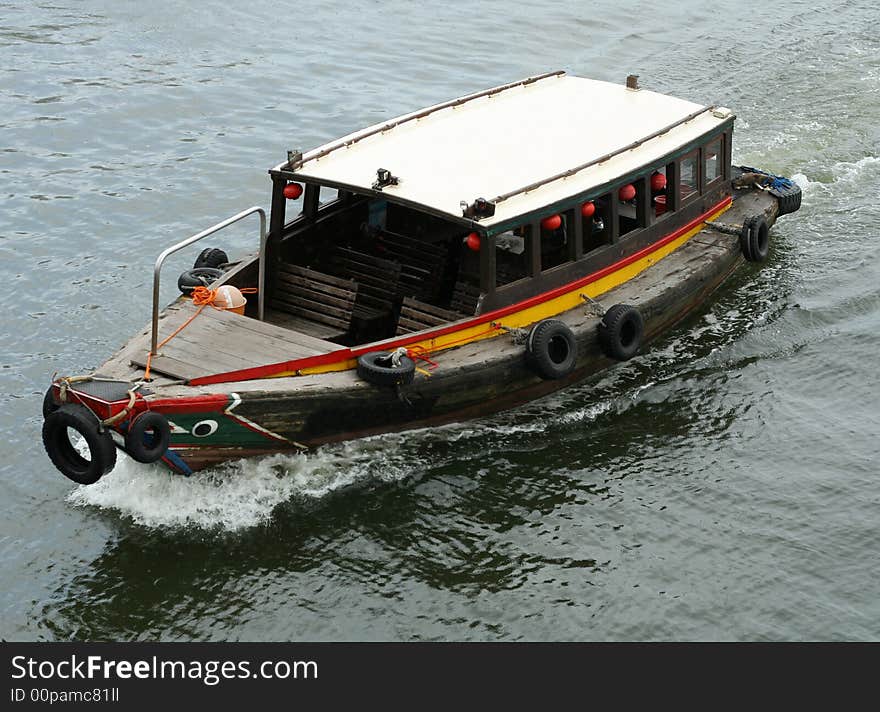 A bumboat travel along a river looking for passengers.