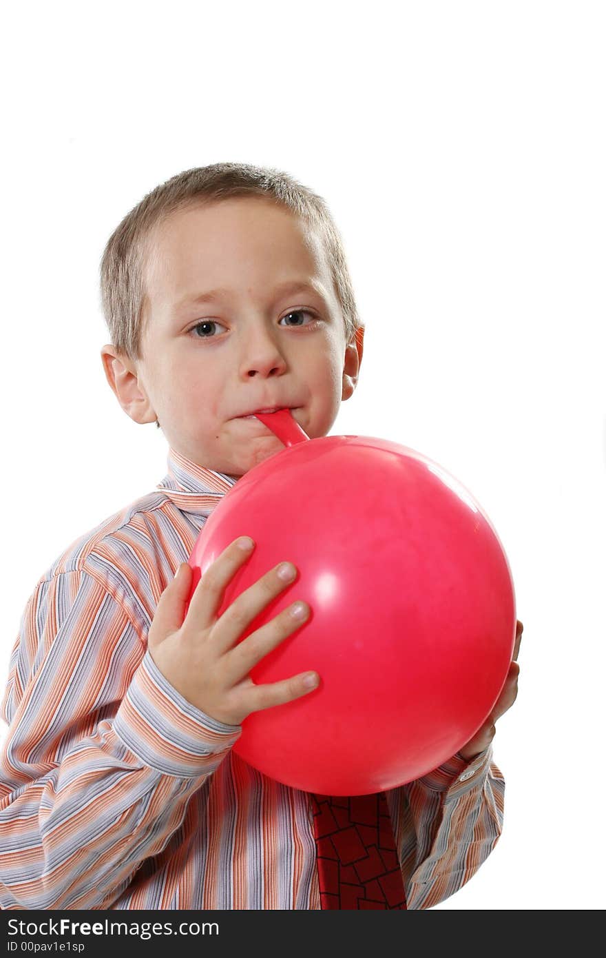 The happy boy inflates a red balloon