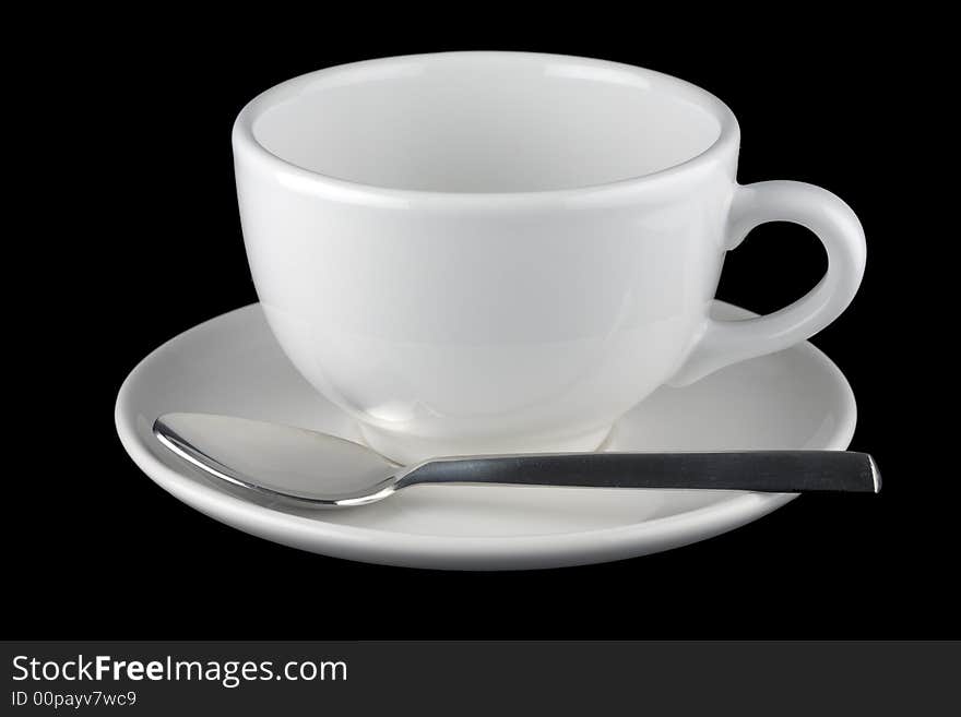 White cup and saucer with spoon, isolated against black background