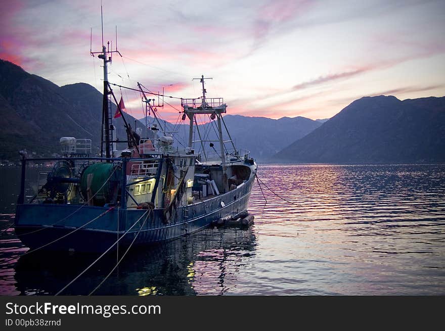 Fishermen boat near mole in sunset. Fishermen boat near mole in sunset