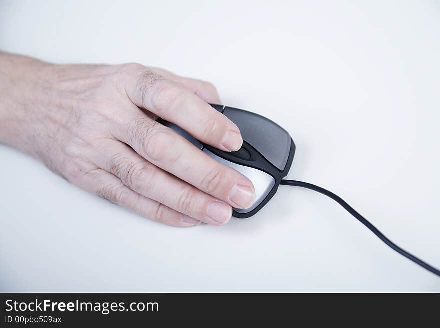 Hand with computer mouse on white table