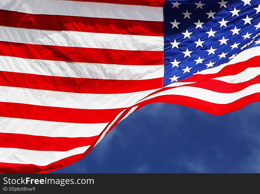 Flowing American flag with blue sky background. Flowing American flag with blue sky background