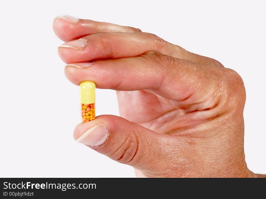 Close up of a capsule in a hand on light background