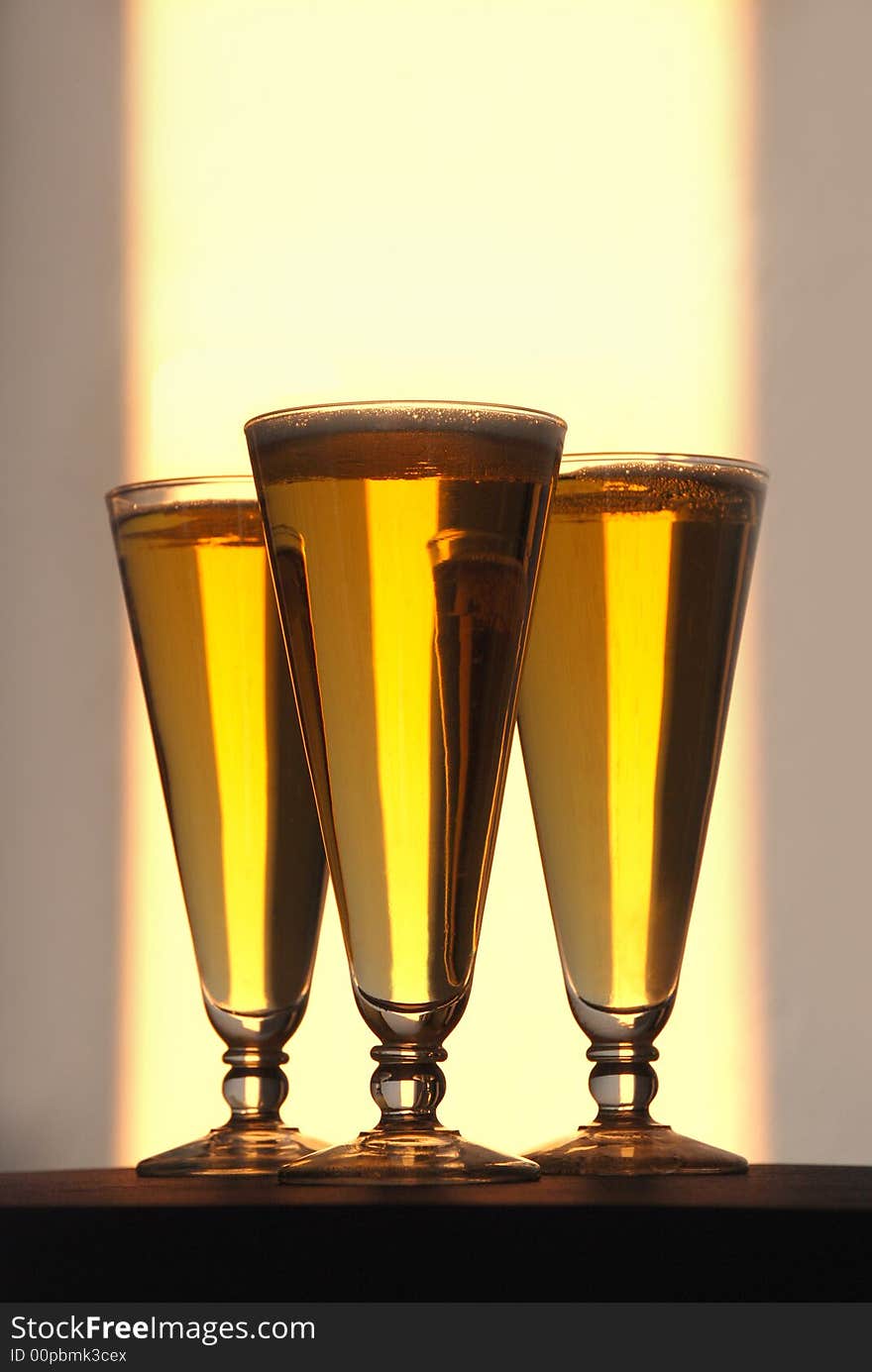 Three tall pilsner beer bottles photographed filled to the brim with ice cold beer. Three tall pilsner beer bottles photographed filled to the brim with ice cold beer.