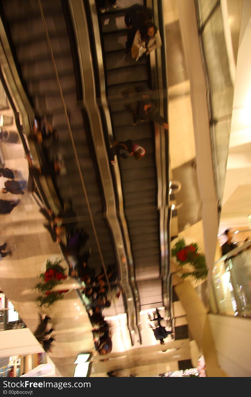 Reflection of people going up and down on escalators at the mall