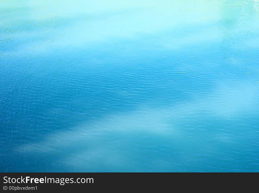 Detail of shadows playing on calm surface of very beautiful blue lake. Detail of shadows playing on calm surface of very beautiful blue lake