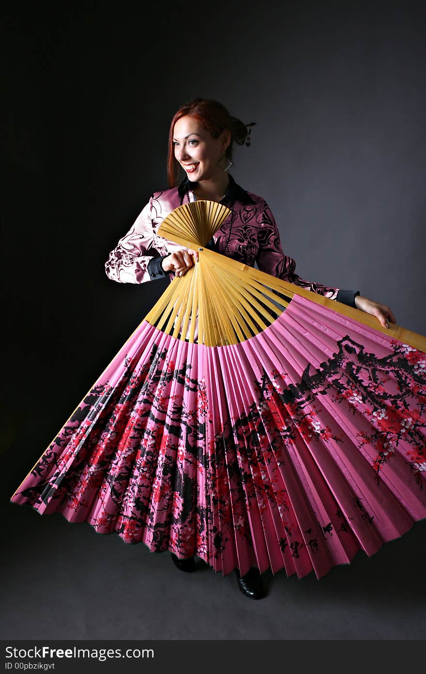 Beautiful girl with japanese pink fan