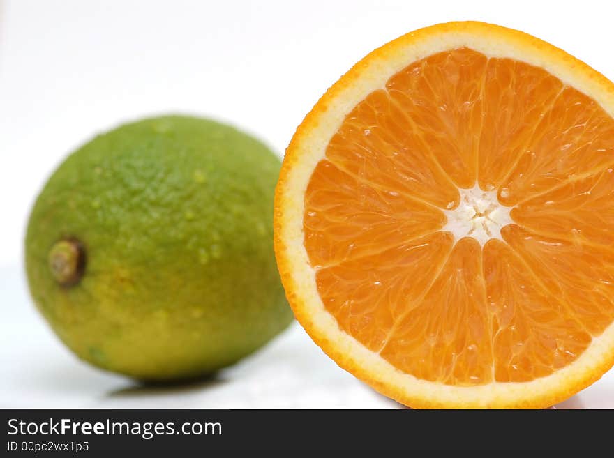 A cut orange, together with a lemon in the background. A cut orange, together with a lemon in the background.