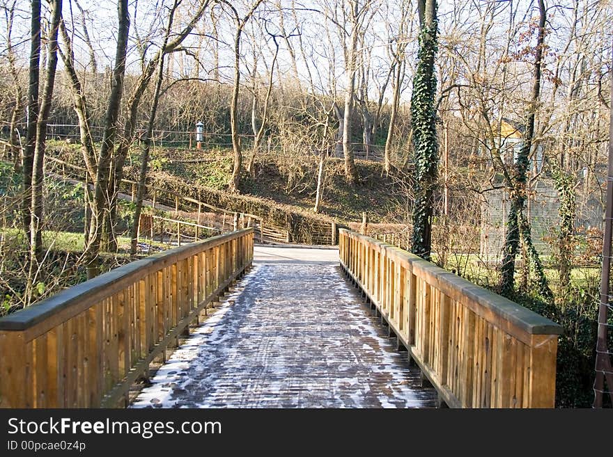 Wooden bridge in a park the frozen with snow. Wooden bridge in a park the frozen with snow.