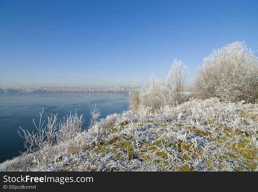 Winter wonderland lake with snow and blue sky