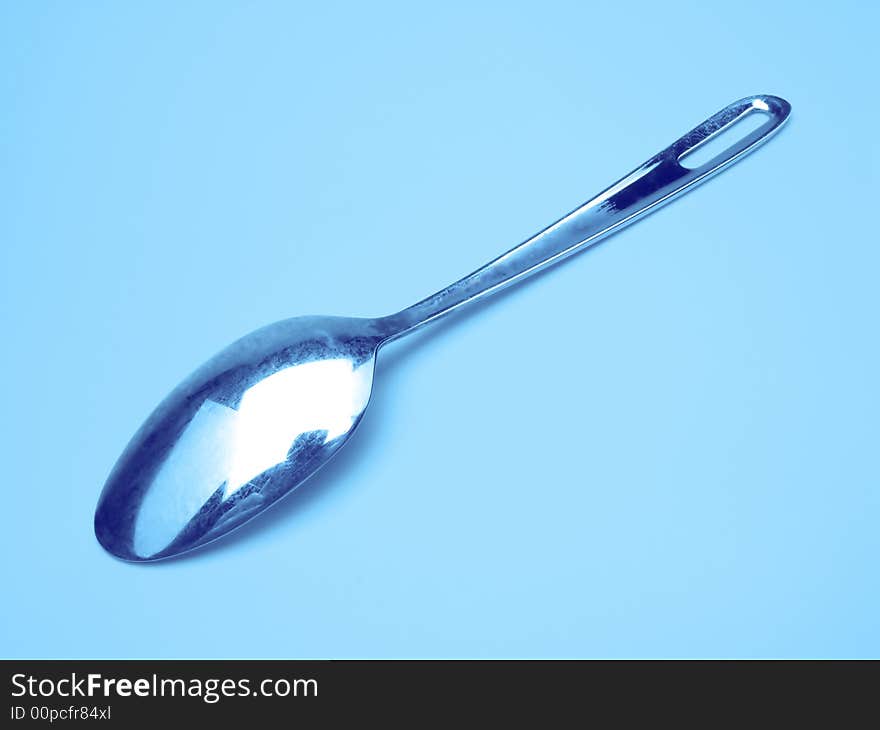 One teaspoon on dark blue background, close up