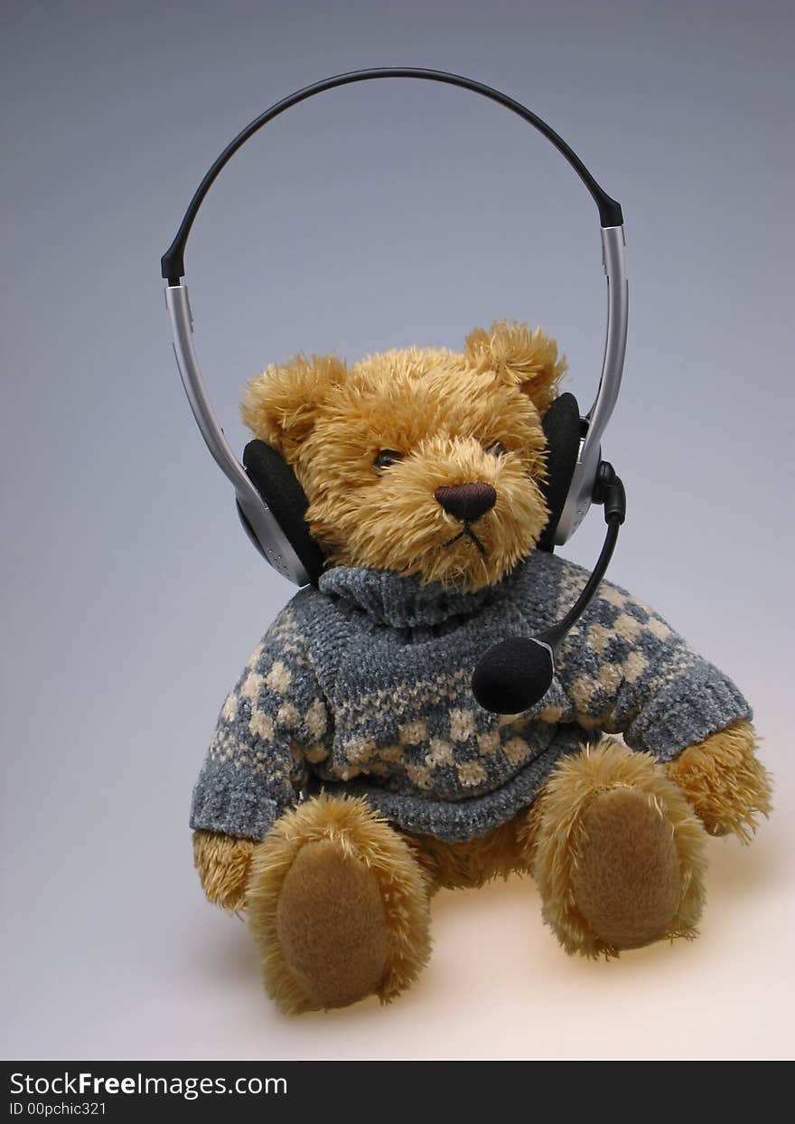 Children's toy bear with speakerphone on head on light background. Children's toy bear with speakerphone on head on light background