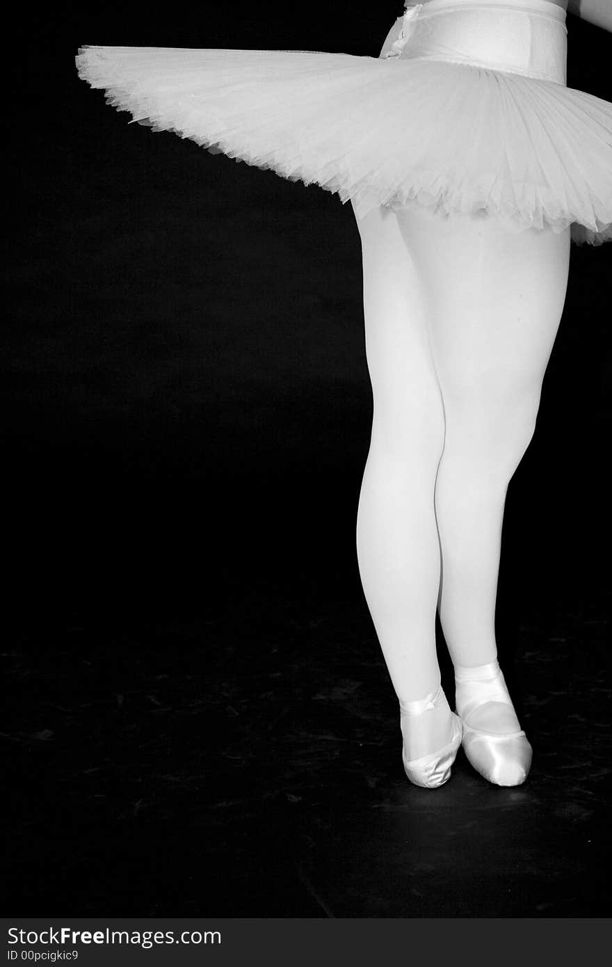 Ballerina in tutu with black background two legs