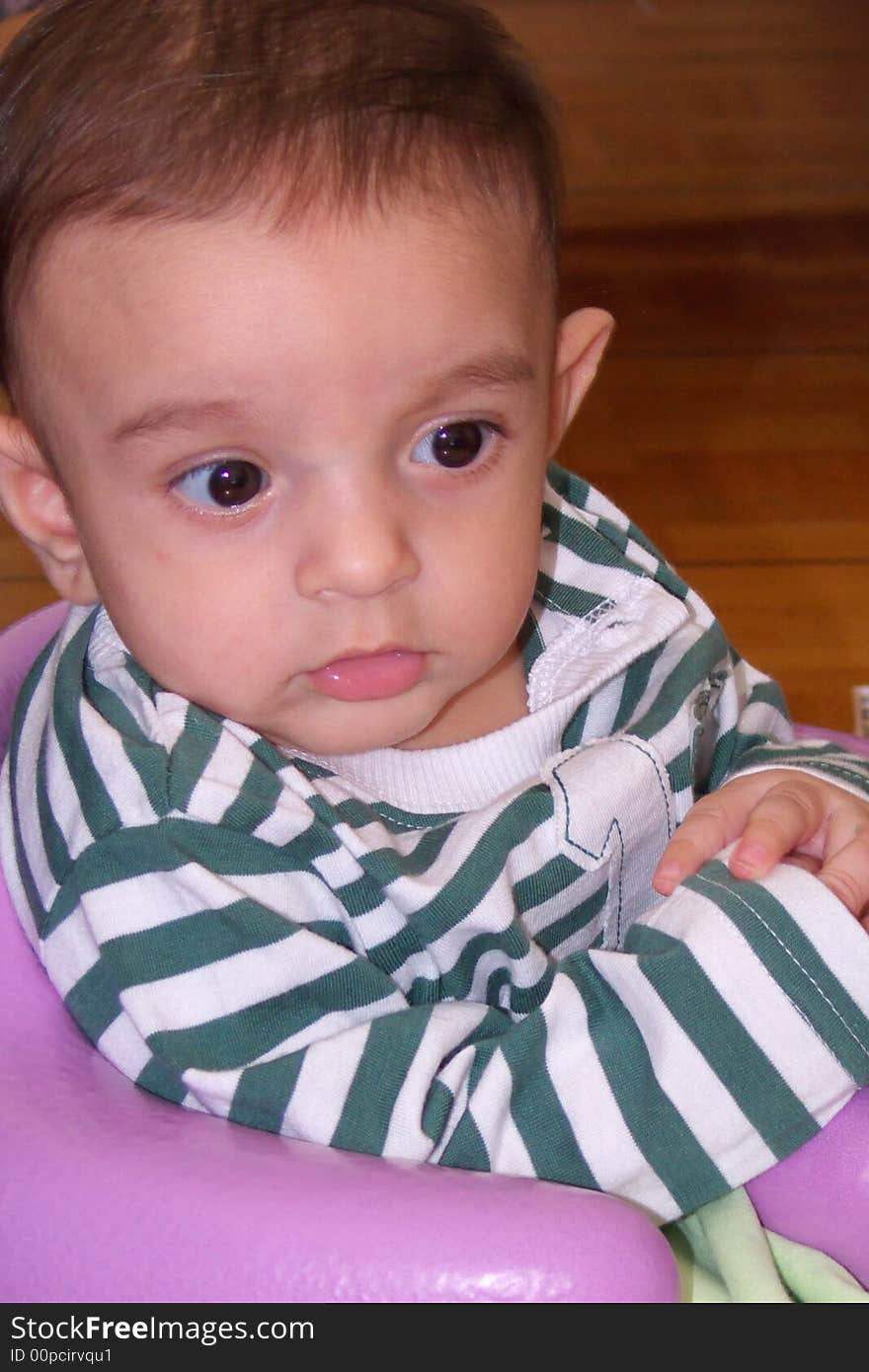 Five month old baby sitting in a baby chair close-up. Five month old baby sitting in a baby chair close-up