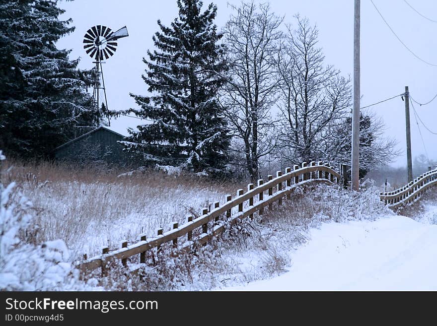 Fence, barn and windmill in the winter at the farm. Fence, barn and windmill in the winter at the farm