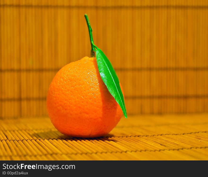 Tangerine witj leaf over bamboo background