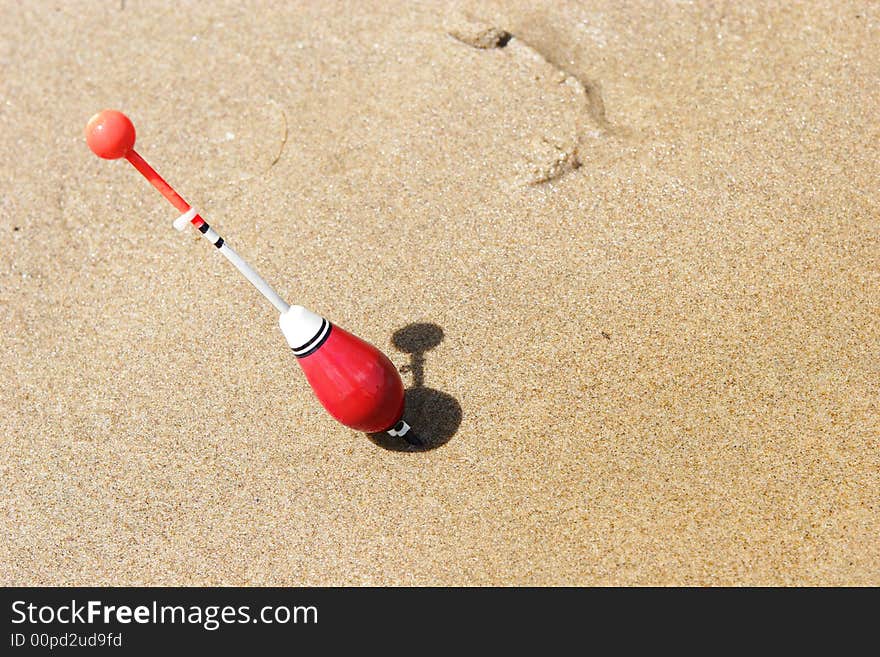 A Fishing Float Sticked Into The Sand