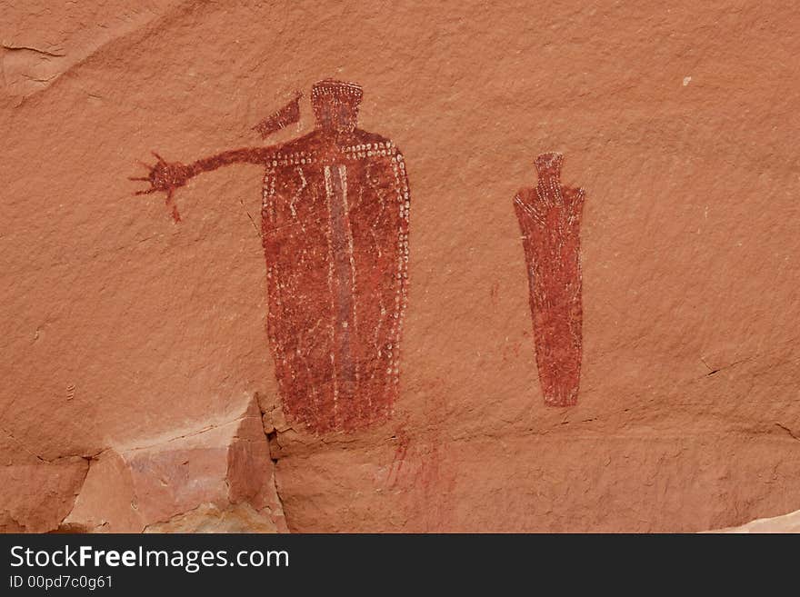 Two ancient Barrier Canyon style pictograph figures on red sandstone in desert southwest. Two ancient Barrier Canyon style pictograph figures on red sandstone in desert southwest