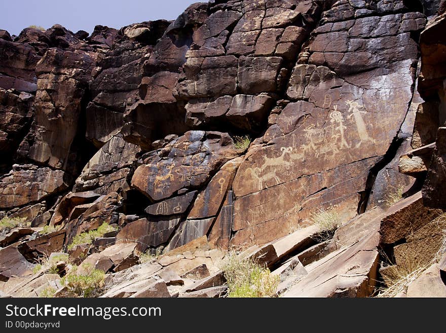 Native American rock art petroglyphs of sheep and anthropomorphic like figures carved into desert varnish covered cliff of Little Petroglyph Canyon in the Coso Range of California. Native American rock art petroglyphs of sheep and anthropomorphic like figures carved into desert varnish covered cliff of Little Petroglyph Canyon in the Coso Range of California