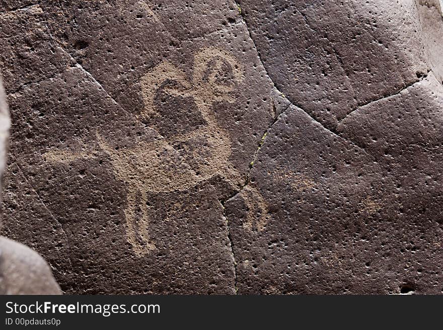 Native American rock art petroglyph close up of sheep like figure carved into desert varnish covered rock in Little Petroglyph Canyon of the Coso Range in California. Native American rock art petroglyph close up of sheep like figure carved into desert varnish covered rock in Little Petroglyph Canyon of the Coso Range in California