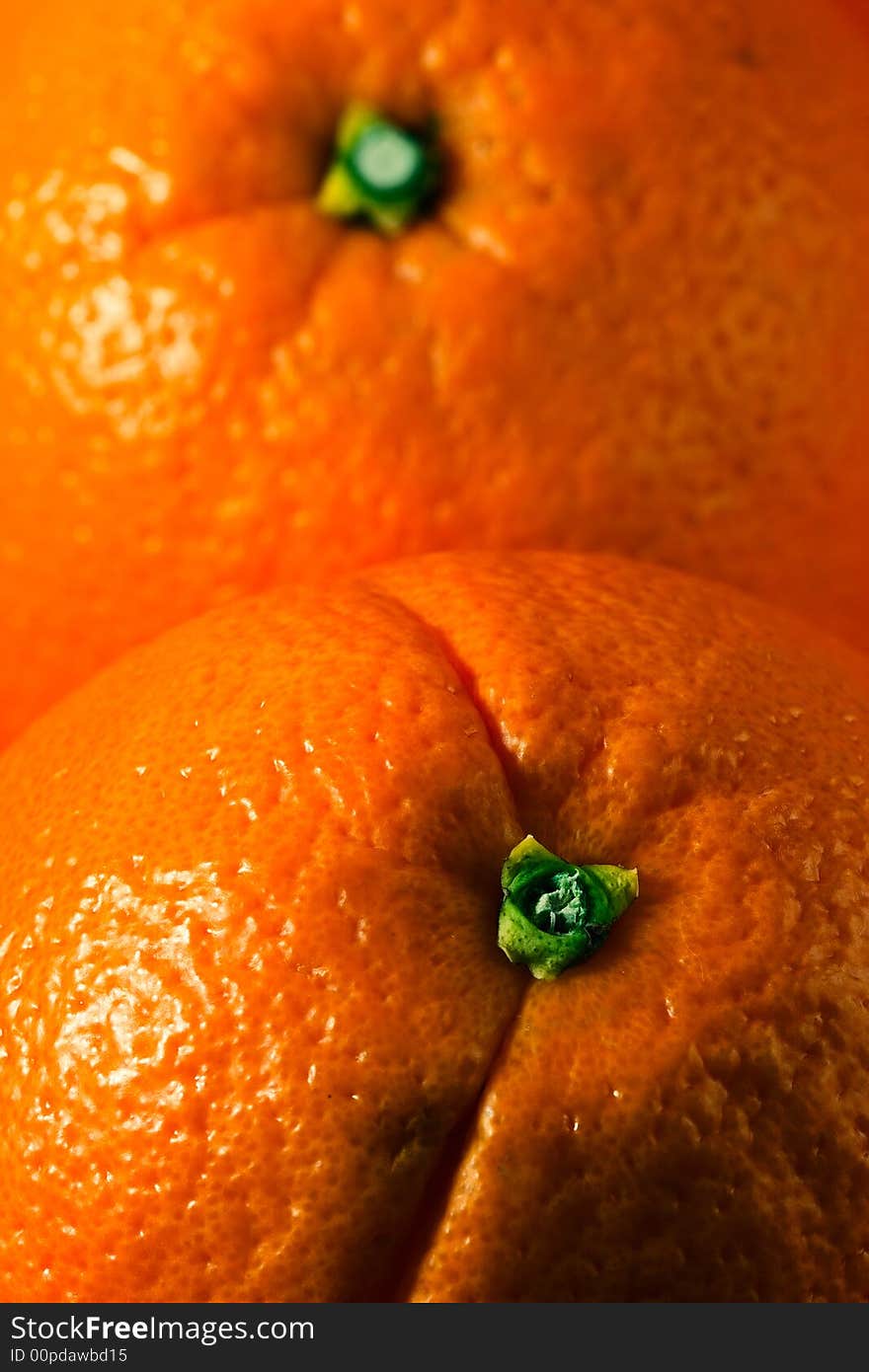 Vertical photo of two whole oranges, each covering half frame. Vertical photo of two whole oranges, each covering half frame