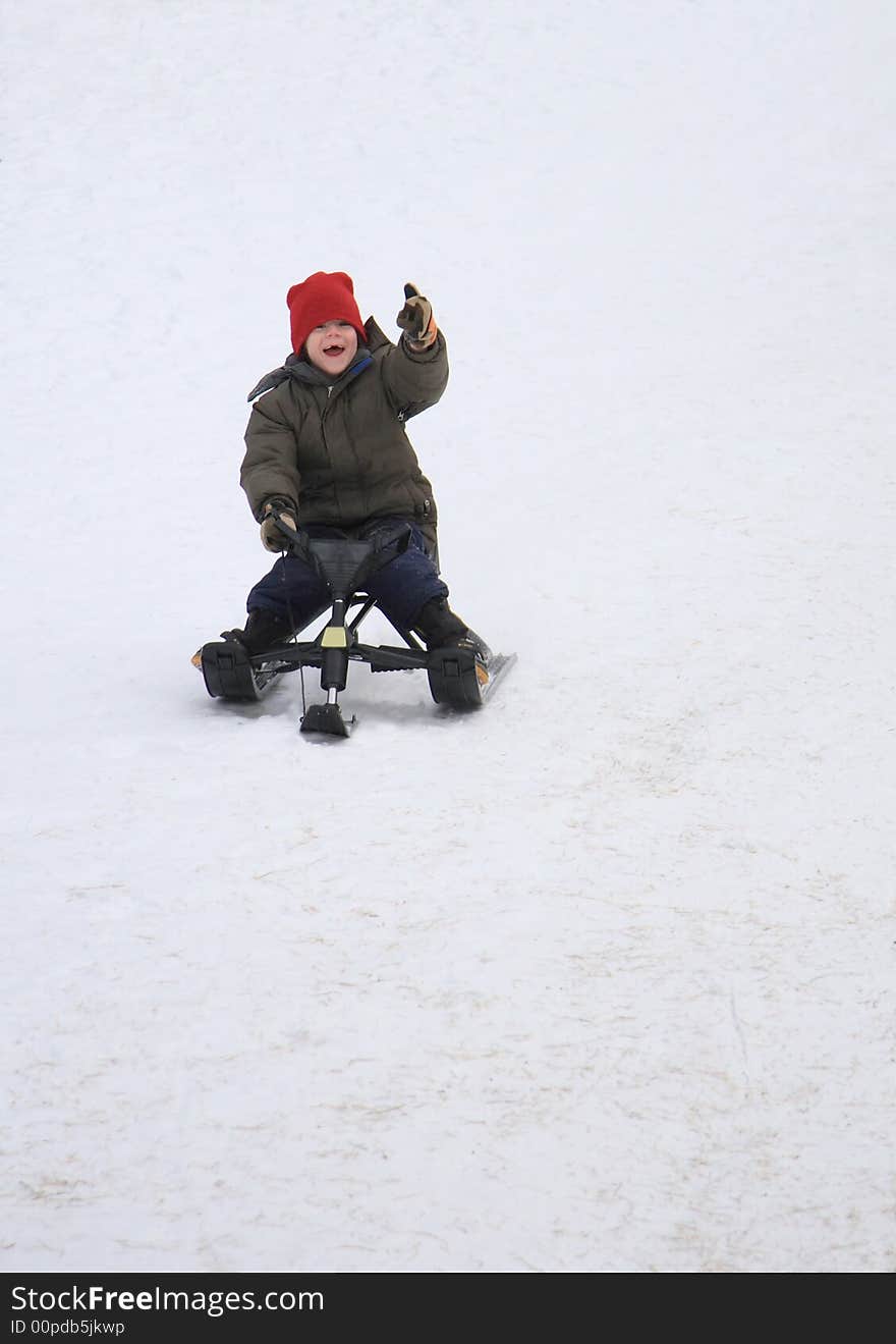 A young boy enjoying a winter day at the toboggan hill. A young boy enjoying a winter day at the toboggan hill