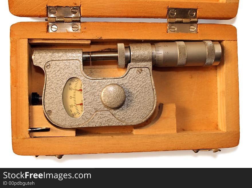 Old micrometer in wooden box isolated