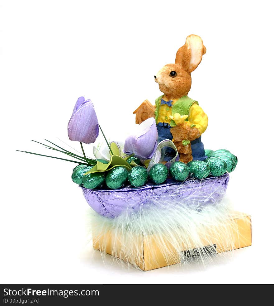 Easter bunny with chocolate eggs and flowers in a basket isolated on white background