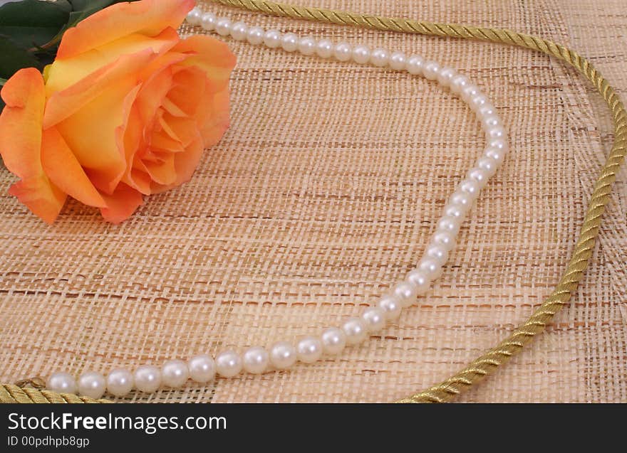 Rose on Textured Background With Pearls and Gold Rope