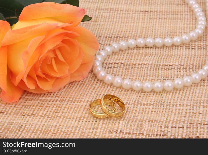 Orange Rose with Gold Wedding Rings and Pearls. Orange Rose with Gold Wedding Rings and Pearls