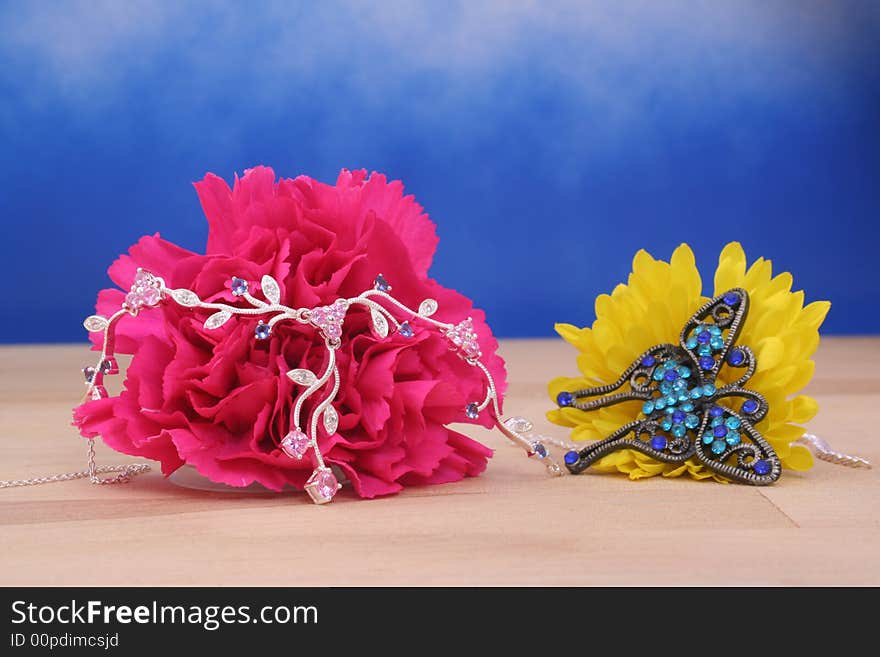 Silver Necklace on Pink Carnation on Blue Background. Silver Necklace on Pink Carnation on Blue Background