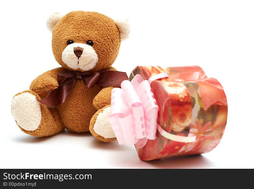 Classic brown Teddy Bear with heart-shaped present. Isolated on white background. Focus on Teddy.