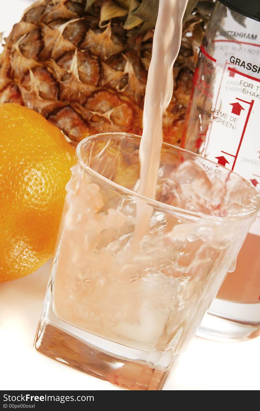 A glass of ice cold juice. Focus is on the top of the glass, background is purposely out of focus