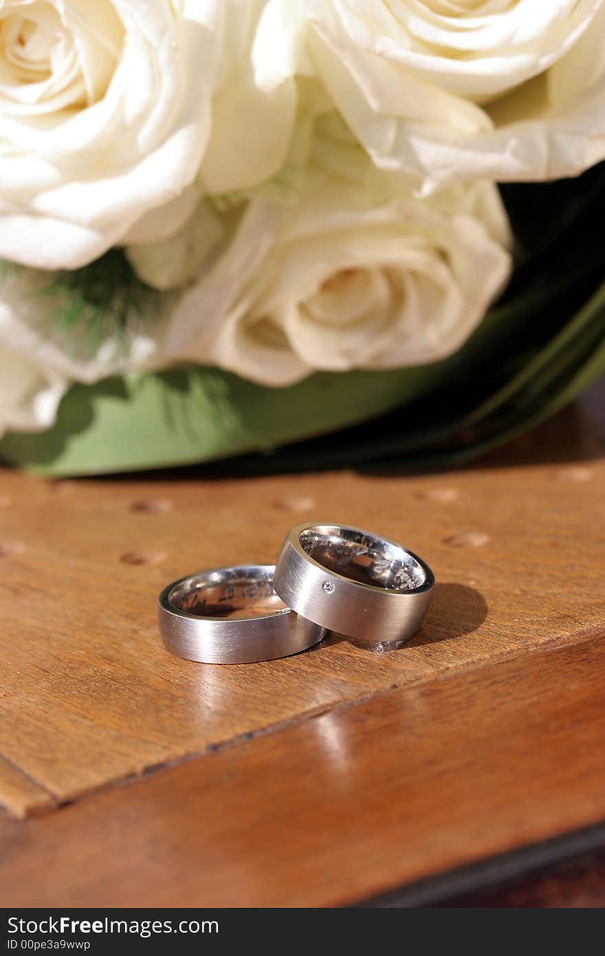 Wedding Rings On Chair With White Roses